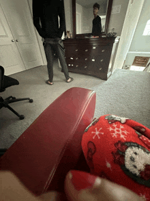 a man standing in front of a dresser in a room with a sign that says " welcome "