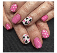 a close up of a woman 's nails with pink and white polka dots and mickey mouse design