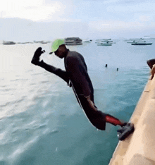 a man is jumping into the water with his leg up