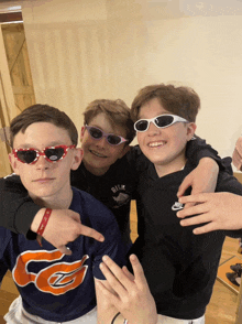 three young boys wearing sunglasses and a shirt that says nike