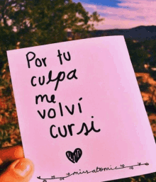 a person is holding a piece of paper that says por tu culpa me volví cursi