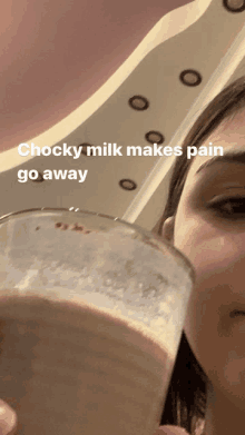 a woman is holding a glass of milk with the words chocky milk makes pain go away