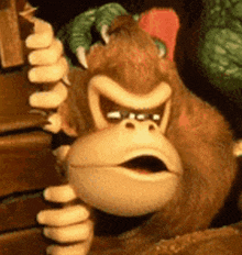 a donkey kong monkey is peeking out from behind a wooden shelf .