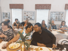 a group of women sit at a table with plates of food in front of them