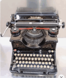 an antique olivetti typewriter is sitting on a table .