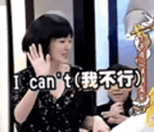 a woman is waving her hand and saying `` i can 't '' in a foreign language .