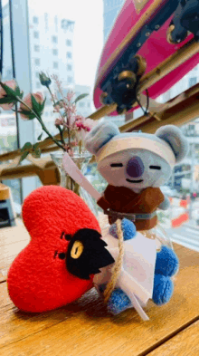 two stuffed animals are sitting next to each other on a table with a skateboard in the background