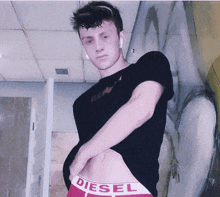 a man wearing a black shirt and red diesel boxer briefs