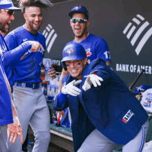 a group of blue jays players are posing for a picture in the dugout