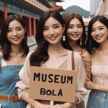 a group of young women holding a sign that says museum bola