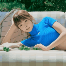 a woman in a blue sweater is laying on a white couch