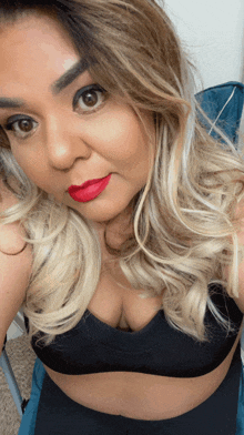 a woman with blonde hair and red lipstick is taking a selfie