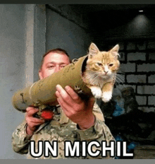 a man is holding a cat in a tube that says un michil on it