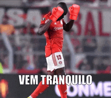 a soccer player wearing red boxing gloves with the words vem tranquilo written below him