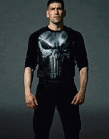 a man is wearing a punisher shirt and black pants