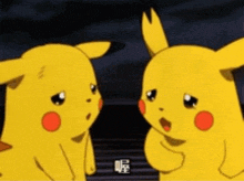 two pikachu cartoon characters are standing next to each other and talking .