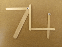 a number 7 is made out of popsicle sticks with googly eyes