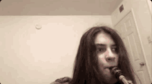 a girl with long hair is playing a saxophone in a room .