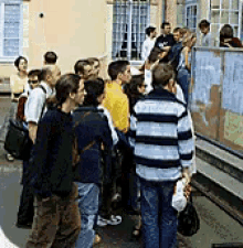 a group of people standing in front of a building with a sign that says ' a ' on it