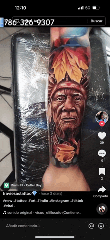 a tattoo of a native american with leaves on his head is displayed on a phone screen