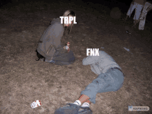 a woman kneeling next to a man laying on the ground with the words trpl and fnx