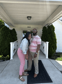 a man and a woman pose for a picture in front of a building