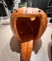 a pumpkin with a tongue sticking out of it 's mouth