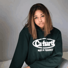 a woman wearing a green carhartt hoodie