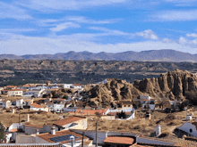 a city with mountains in the background and a blue sky