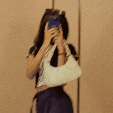 a blurry picture of a woman taking a selfie with her phone