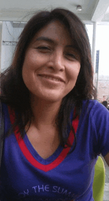 a woman wearing a purple shirt that says " on the sun " smiles for the camera