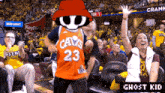 a man wearing a cavs jersey is dancing in front of a crowd