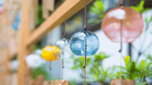 a blue wind chime hangs from a wooden beam