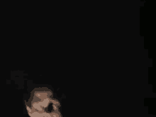 a blurry picture of a man holding a microphone in the dark .