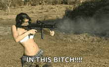 a woman in a bikini is holding a gun in a field and says in this bitch .