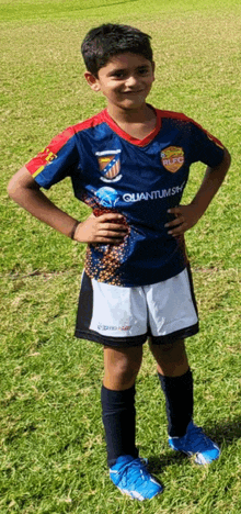 a young boy wearing a quantum sky soccer jersey