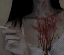 a woman is smoking a cigarette with blood coming out of her chest and neck .