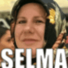 a close up of a woman 's face with the word selma in white letters .