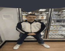 a man standing in front of a vending machine that has a sign on it that says ' no smoking '