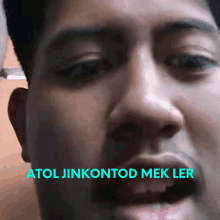 a close up of a man 's face with the words atol jinkontod mek ler above it