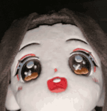 a close up of a stuffed animal with big eyes and a red lip