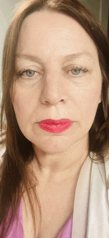 a close up of a woman 's face with red lipstick on