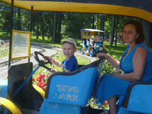 a woman sits next to a boy in a blue divo arr vehicle