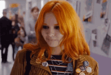 a girl with orange hair has a lot of buttons on her jacket including one that says " coca cola "