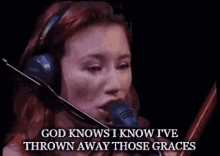 a woman wearing headphones singing into a microphone with the words god knows i know