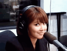 a woman wearing headphones and a microphone looks at the camera