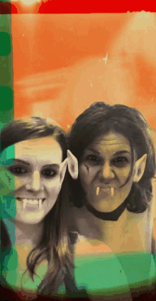 two women with vampire makeup on their faces pose for a photo