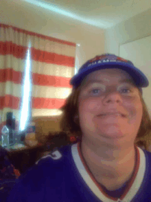 a woman wearing a buffalo bills hat and a jersey smiles for the camera