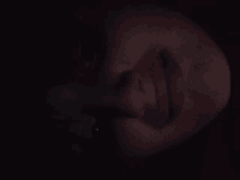 a close up of a person 's face in a dark room .