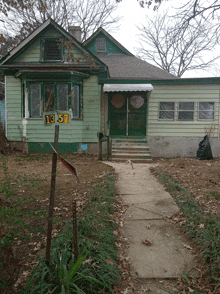 a green house with the number 13-53 on the front of it